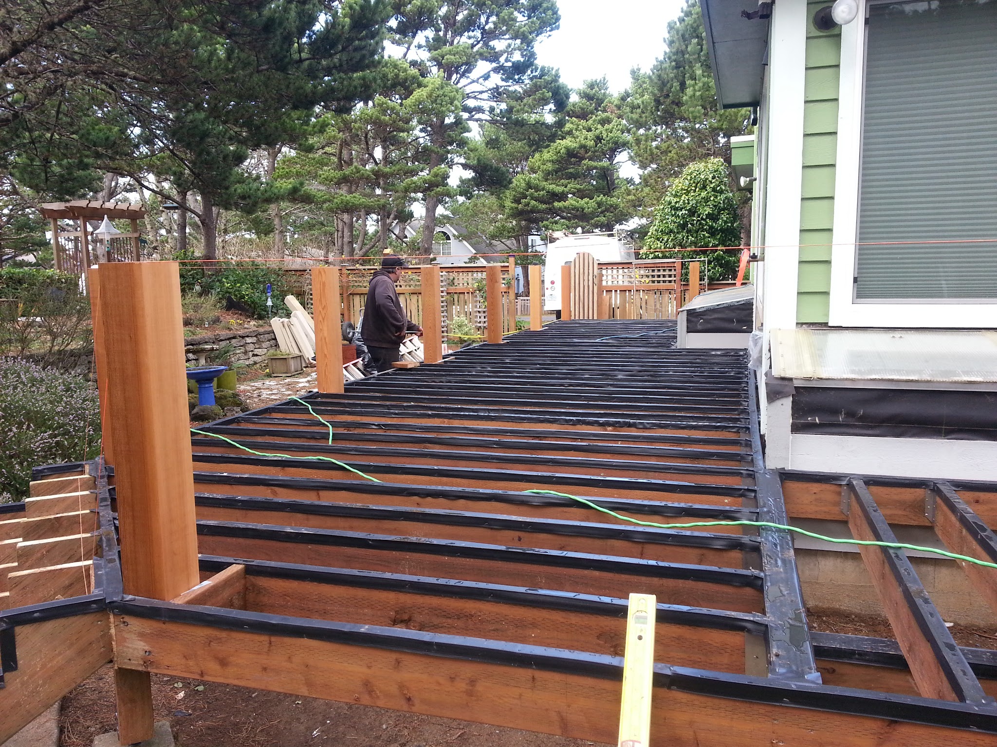 Deck framing under construction with a crew member on site